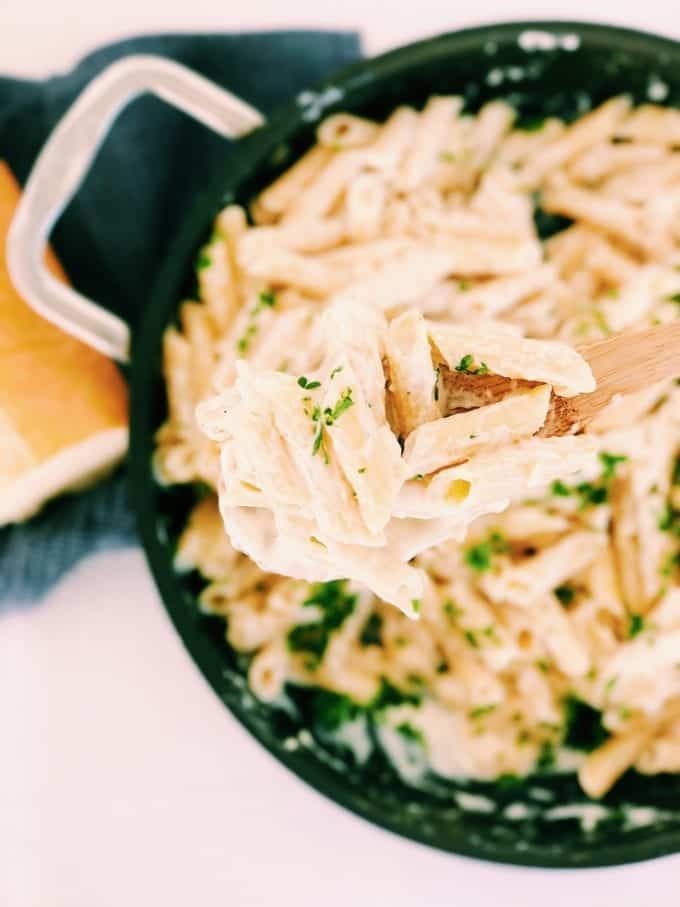 Close up of penne pasta on wooden spoon