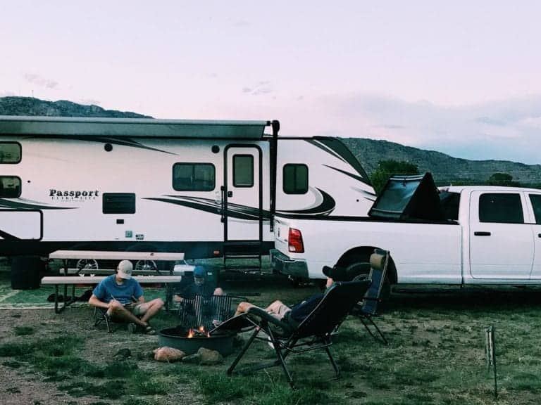 Father and son relaxing outdoors at campsite.