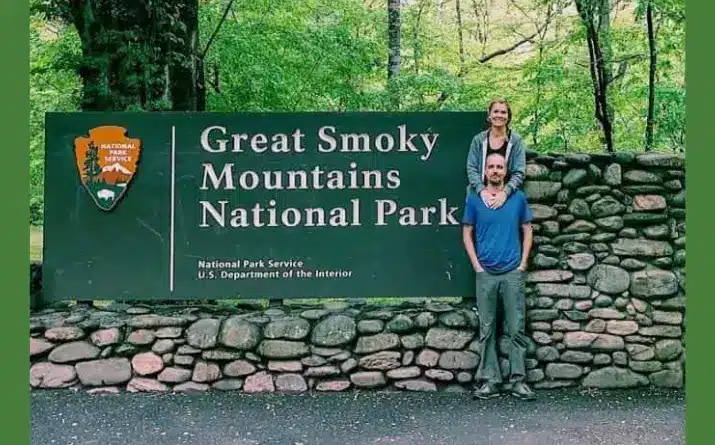 Man and woman in front of entrance sign at Great Smoky Mountains National Park