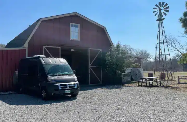 Campervan in front of red barn at a Harvest Hosts location