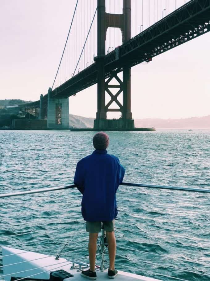 Teen boy at helm of sailboat in San Francisco Bay