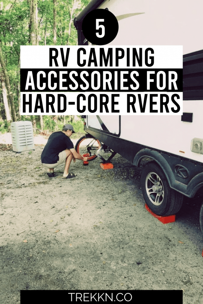 Man using a drill to set the stabilizing jack under the travel trailer.