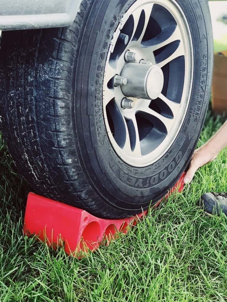 Close up of RV tire being set on a block to keep the trailer level.