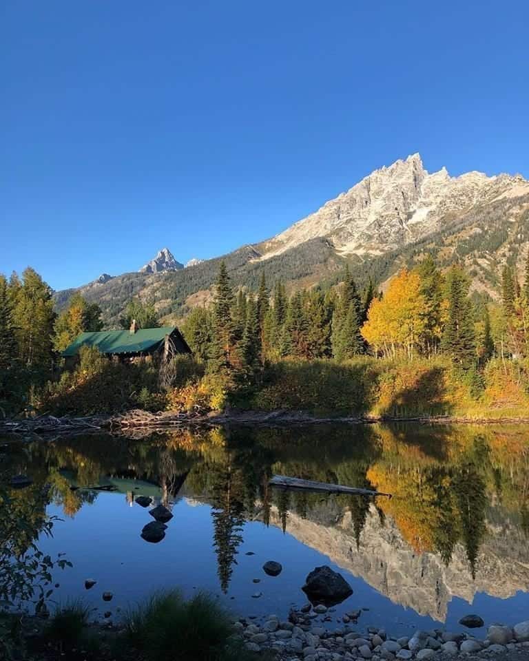 Ssnow-capped mountain reflecting on surface of lake in Grand Teton National Park