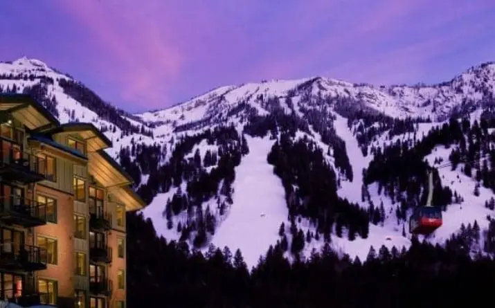 Ski trails at a resort in Jackson Hole with blue and red sunset visible over mountain.