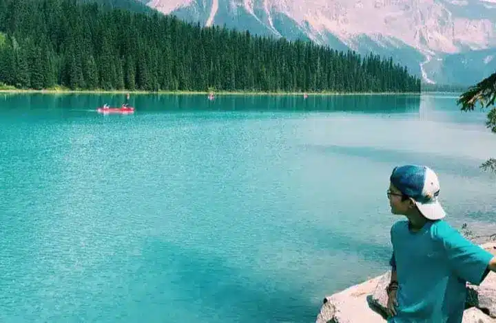 Teen standing on edge of lake at Yoho National Park