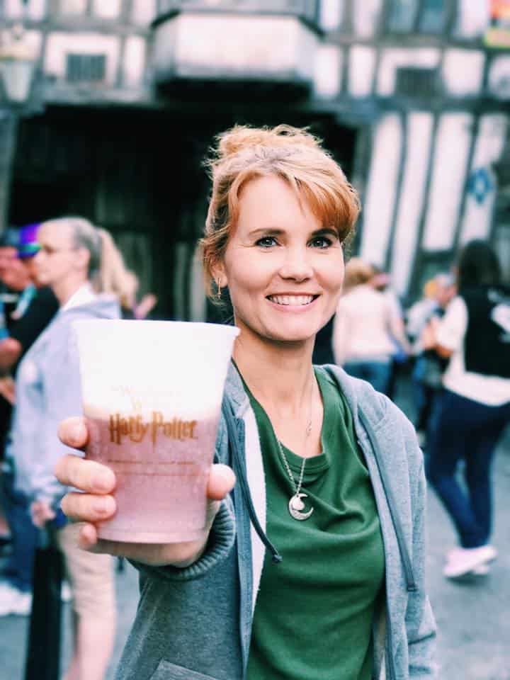 Woman at Universal Studios in Orlando holding a cup of butter beer