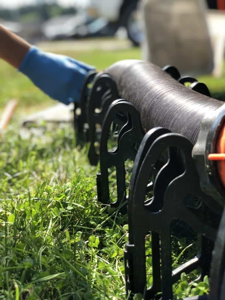 Man's gloved hand is setting up the RV sewer system at a campsite