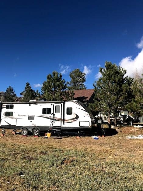 Travel trailer parked in yard near a house