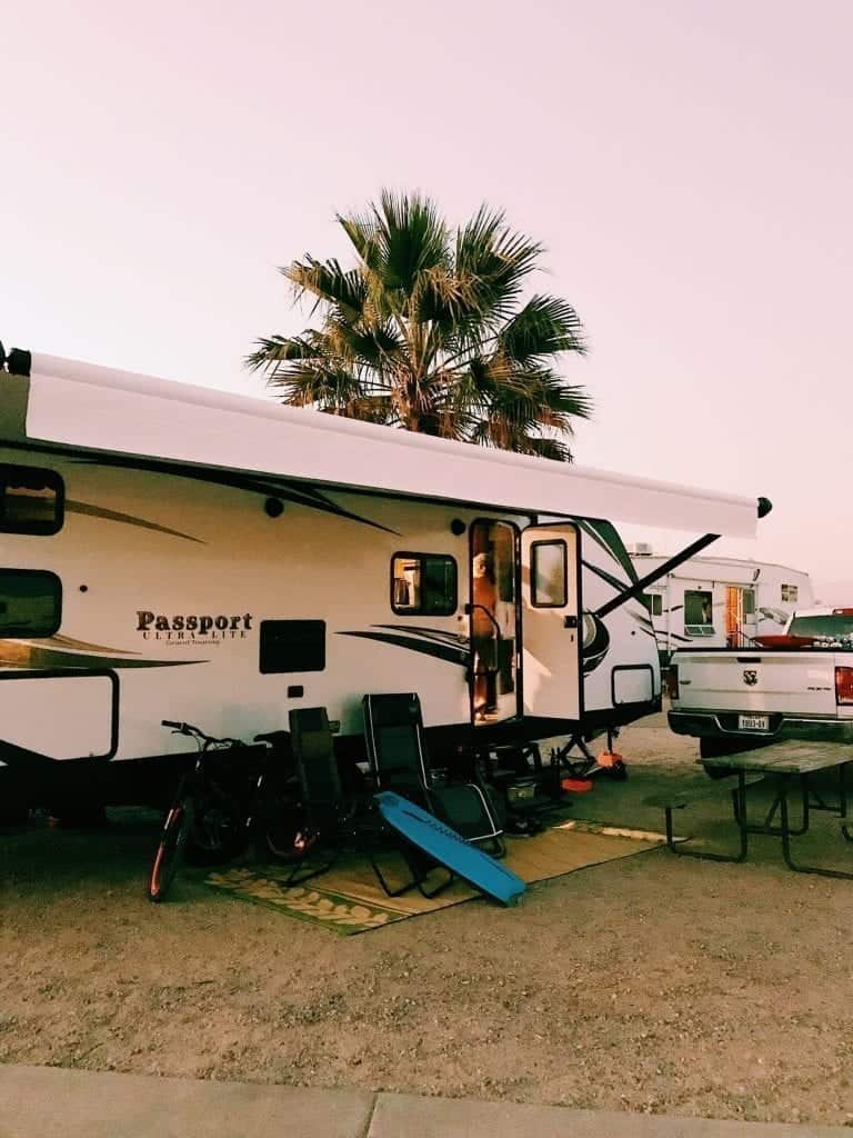 Keystone passport travel trailer parked and set up at campsite.