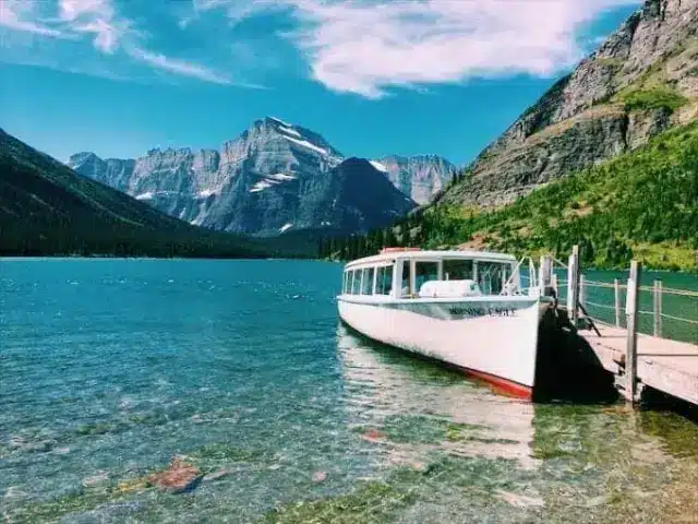 White boat docked on lake at Glacier National Park