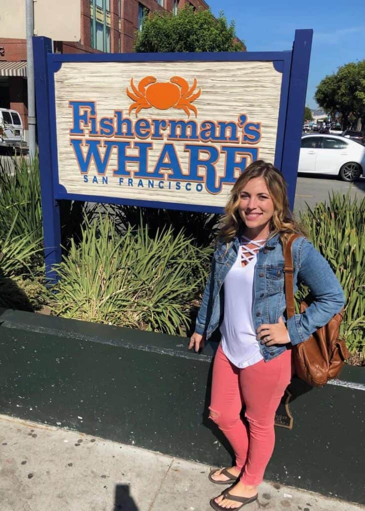 Woman posing in front of Fisherman's Wharf sign in San Francisco