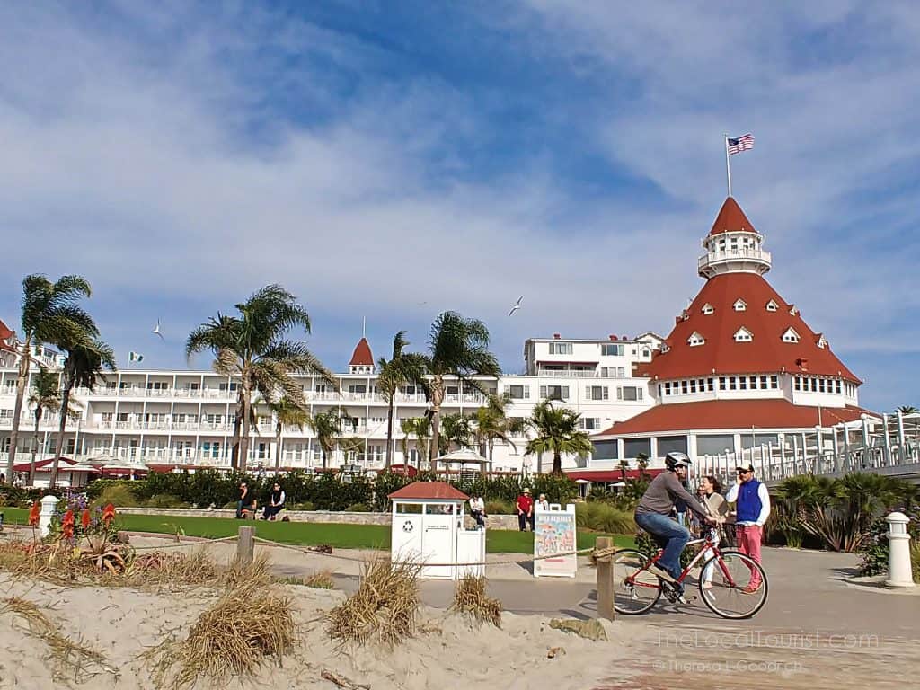 Bike rider and tourists on boardwalk in San Diego