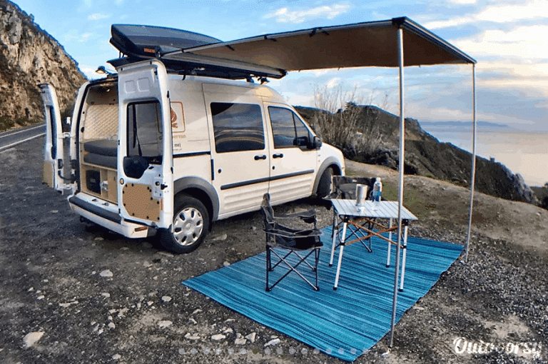 Camper van and awning set up above picnic area in California