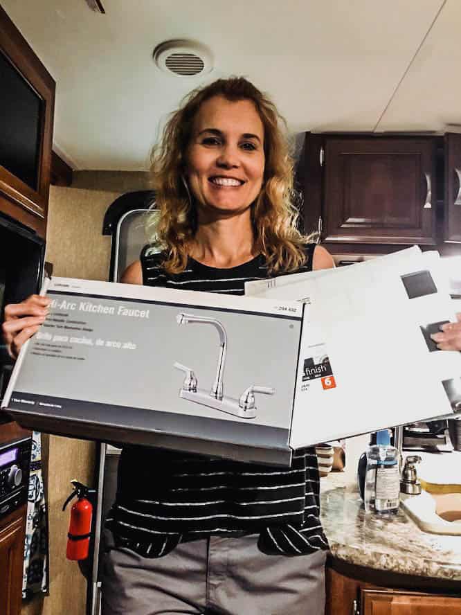 Woman holding kitchen faucet used in RV renovation