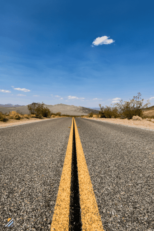 Empty roadway with one cloud in sky