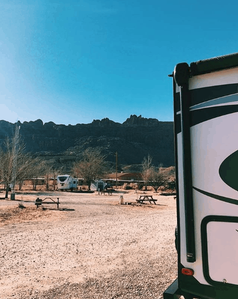 Back of RV parked in a fairly empty campground in Utah.