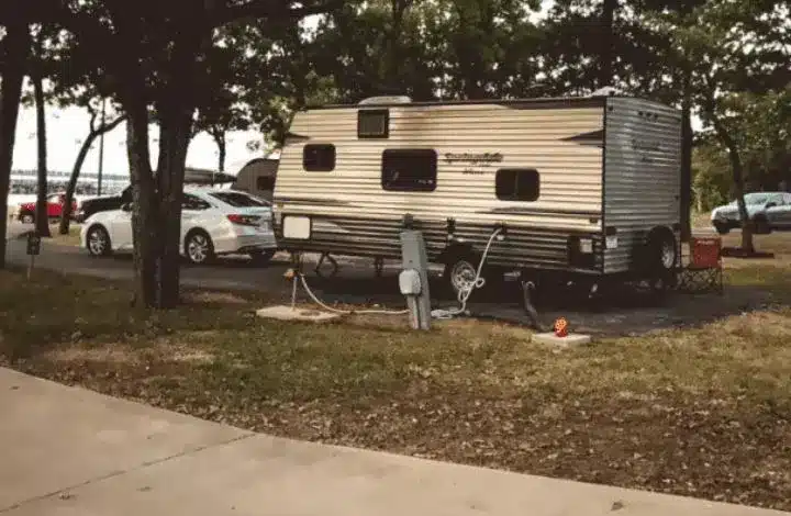 White travel trailer parked and leveled at campsite