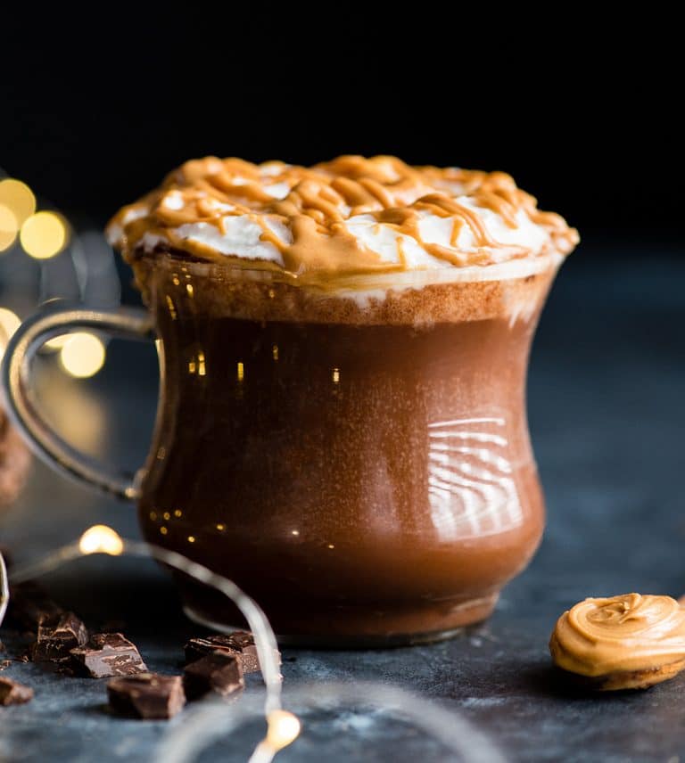 Glass mug filled with peanut butter hot chocolate and whip cream