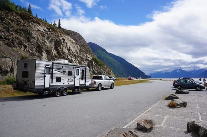 Truck pulling travel trailer on road near lake