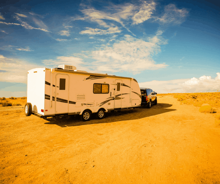 Truck pulling travel trailer motor home through desert