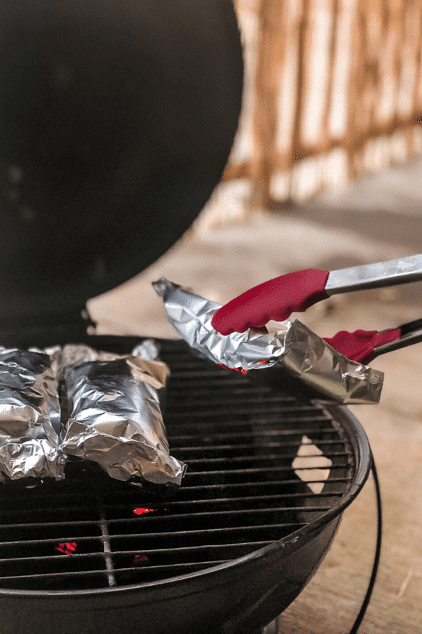 Remove foil packet breakfast burrito from camping grill