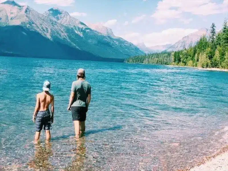 Father and son wading in lake.