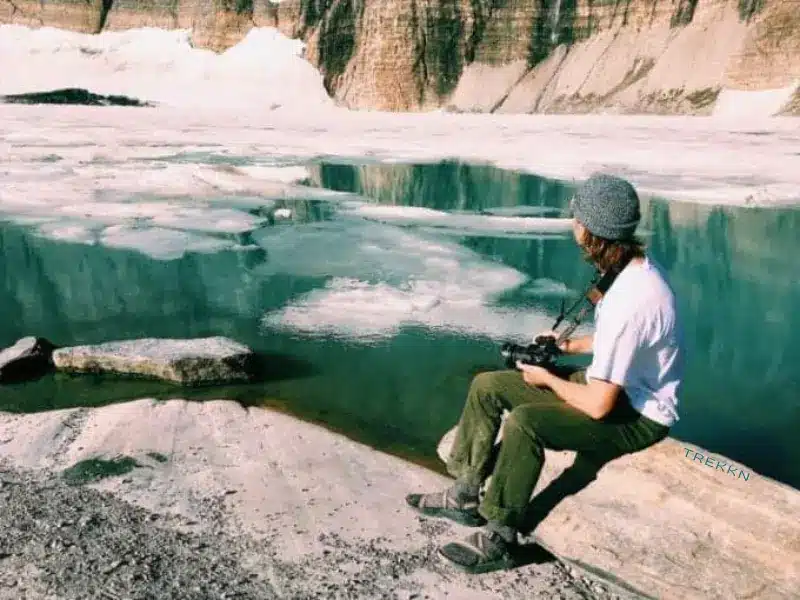 Photographer sitting on rock at Grinnell Glacier.