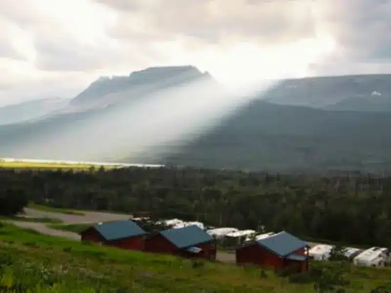 Sun shining through clouds above RV campground.