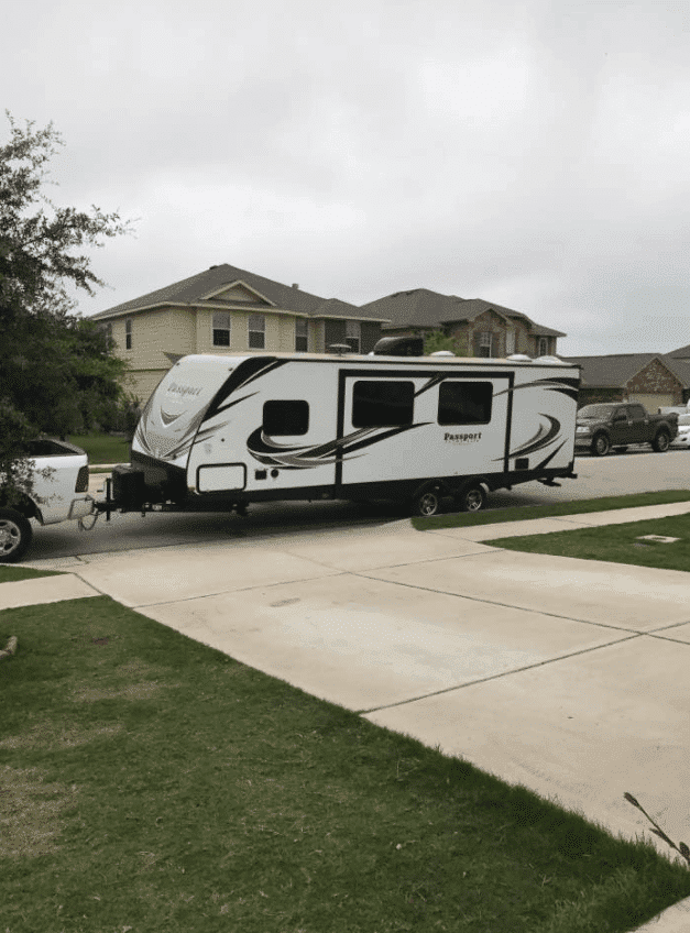 Fifth wheel parked near driveway bought used for RV trip