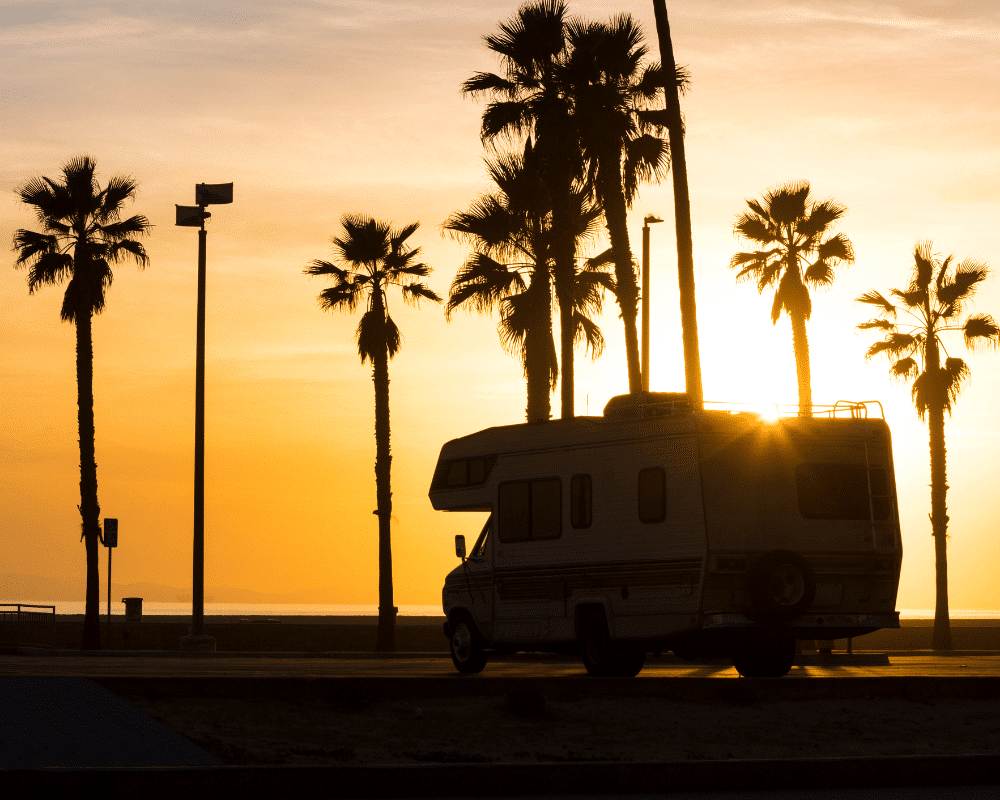 Small RV driving near beach at sunset