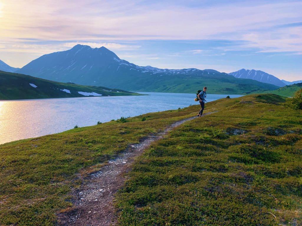 Man on hiking trail along lake near Seward Alaska