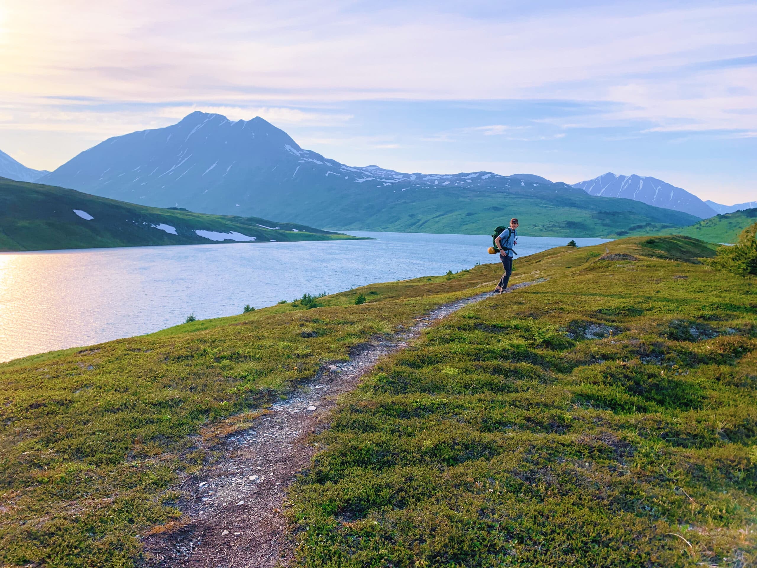 One hiker on trail near lake