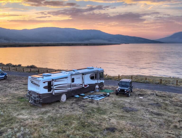 Large RV and Jeep near lake