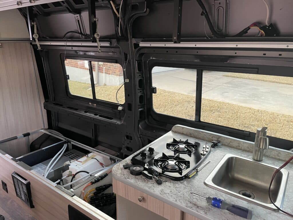 Cabinet counter and siding inside camper van removed to allow owner to install inulsation