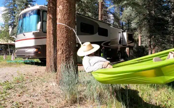 Woman sleeping in hammock next to her RV