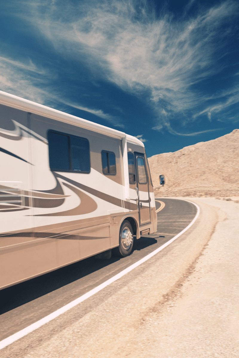 Side of large RV driving around corner