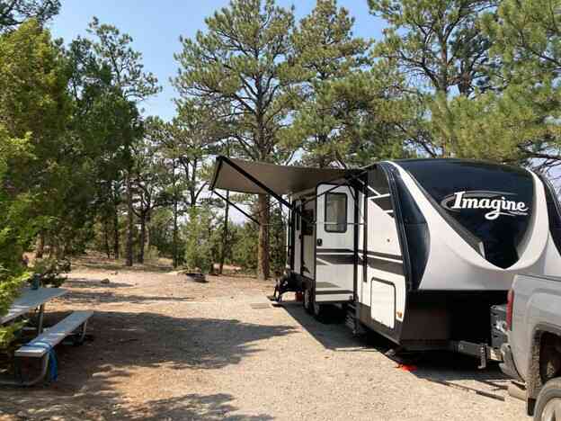 Black and white 25 foot RV parked at campsite