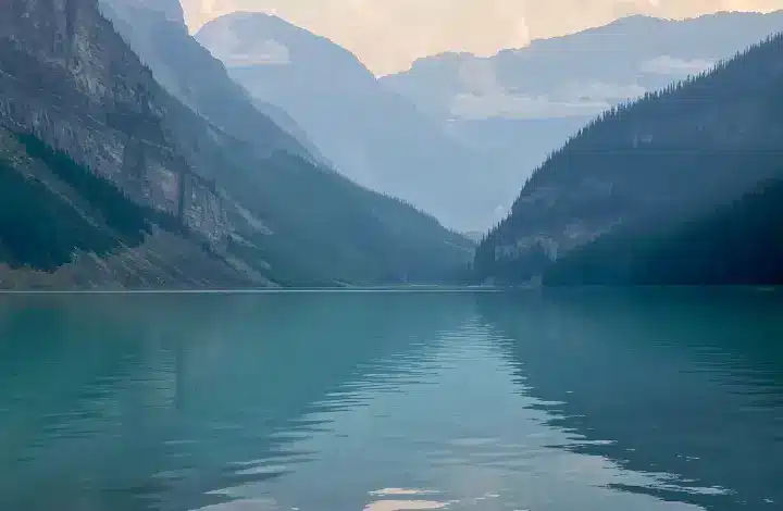 Blue waters of Lake Louise with mountain peaks in background.