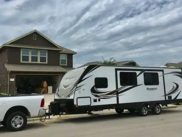 Travel trailer parked in front of house.