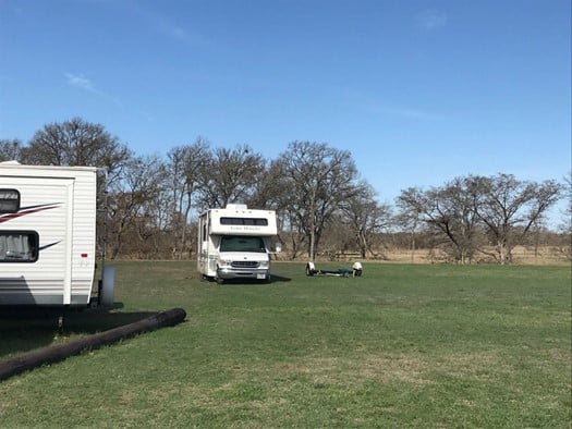 Class C RV rental stuck in mud in middle of grass field